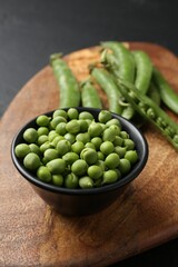 Fresh ripe green peas on black table, closeup