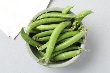 Fresh ripe green peas on grey table, top view