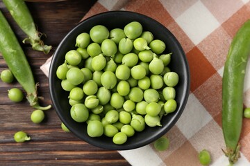 Fresh ripe green peas on wooden table, flat lay