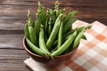 Fresh ripe green peas on wooden table, closeup