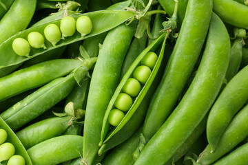 Fresh green peas and pods as background, top view