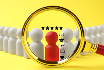 Employee search. Red pawn among white ones on yellow background, view through magnifying glass
