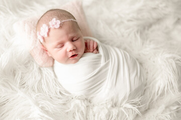 Newborn Baby Girl In Swaddle Blanket Sleeping During Studio Photoshoot