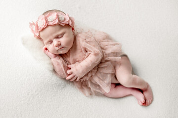Studio Photoshoot Of A Newborn Baby Girl Sleeping In A Pink Dress With A Headband