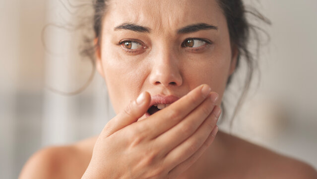 Woman is checking smell of breath