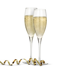 Glasses of sparkling wine and golden serpentine streamer on white background
