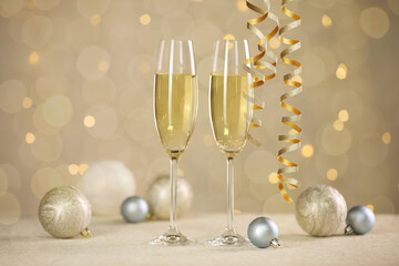 Sparkling wine, golden serpentine streamers and Christmas balls against blurred lights