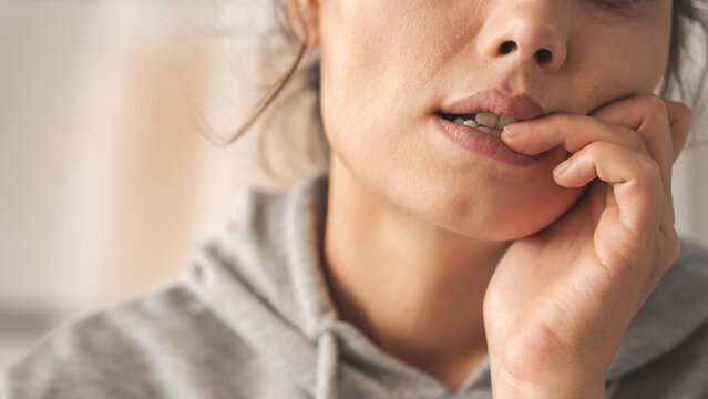 Nervous young woman biting her nails
