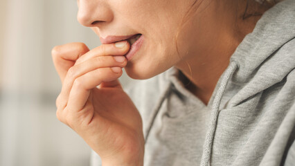 Nervous young woman biting her nails