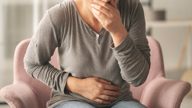 Young woman feeling nauseated at home