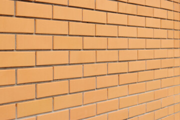 Brick wall background from the side with selective focus. Orange brick background for exterior...