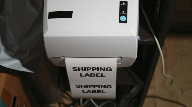 Thermal printer printing a parcel label, torn off by a male hand