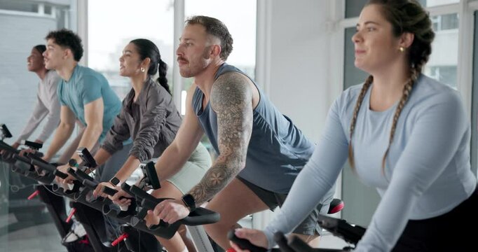 Happy people, instructor or fitness with cycling in spin class for group exercise or workout at gym. Active, team or community on stationary bicycle with coach for cardio training, health or wellness