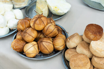 Showcase of delicious farm cheeses from fresh white to aged and smoked for sale at an outdoor fair