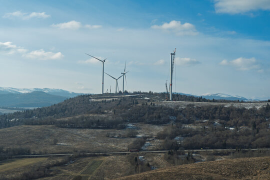 The construction of a wind turbine farm on a scenic mountain landscape