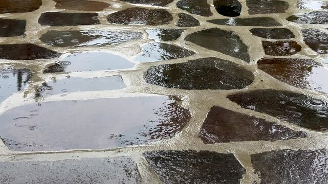 A tranquil background showing the beautiful texture of wet flagstones with sky reflecting in the puddles