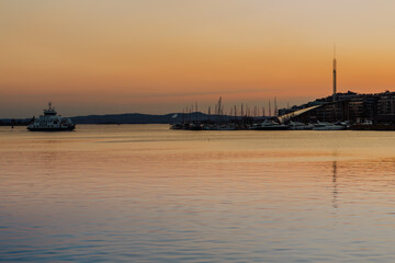 Bathed in the warm glow of sunset, Oslo harbour showcases traditional colourful wooden houses along...