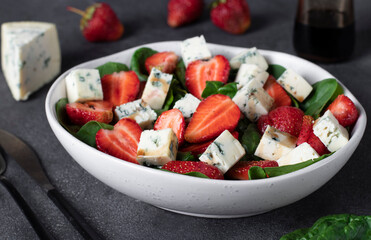 Healthy salad with strawberries, spinach and cheese dor blue, dressed with balsamic