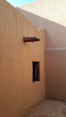 Sunlit Clay Wall with Wooden Beam