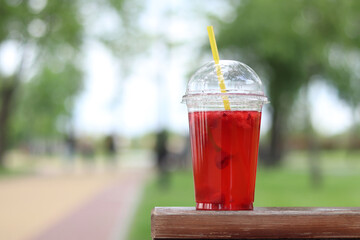 Lemonade in a disposable plastic cup, takeaway drink. Refreshing drink against the background of a...