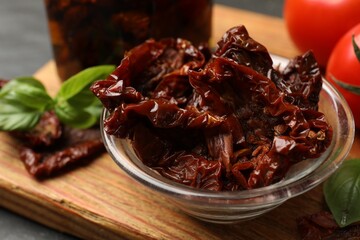 Tasty sun dried tomatoes and fresh vegetables on black table, closeup