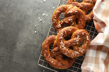 Tasty pretzels with salt on grey table, top view. Space for text