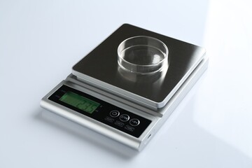 Laboratory scale with Petri dish on white background, closeup