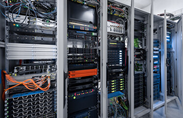 Six server racks with opened doors. Server room with numerous computers and routers. Data center.