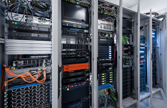 Six server racks with opened doors. Server room with numerous computers and routers. Data center.