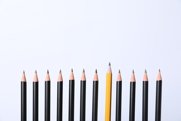 Many sharp graphite pencils on white background. Space for text