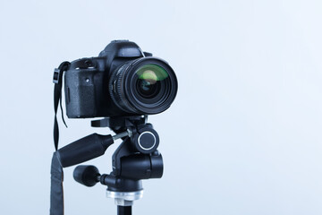 Modern professional video camera on light grey background, closeup. Space for text