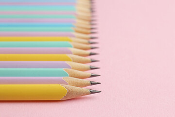 Many graphite pencils on pink background, closeup. Space for text