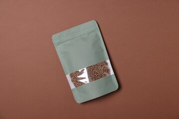 One zipper stand-up pouch with seeds on brown background, top view. Mockup for design