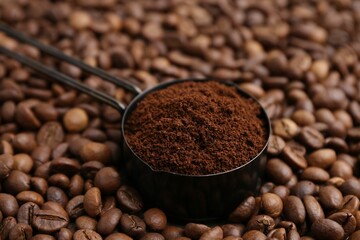 Scoop with instant coffee powder on beans, closeup