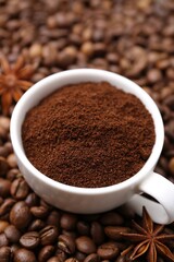 Cup with instant coffee powder and star anise on beans, closeup