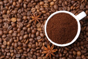 Cup with instant coffee powder and star anise on beans, top view. Space for text