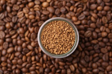 Glass jar with granulated instant coffee on beans, top view