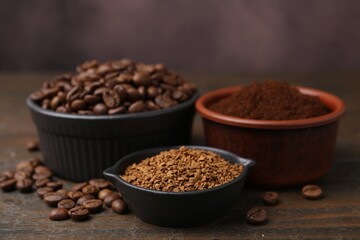 Different types of instant coffee and beans in bowls on wooden table against brown background, closeup