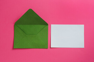 Blank invitation card and envelope on pink background, flat lay. Space for design