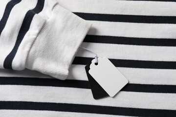 Cardboard tags on striped garment, top view