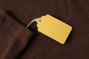Cardboard tag on brown garment, top view