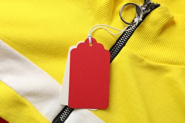 Cardboard tags on colorful garment, top view