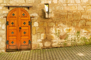 Exquisite antique wooden door in the stoned wall with cobblestone street, Tokaj wine region, Hungary