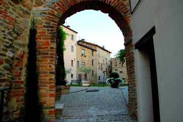 COMUNANZA, ITALY - AUGUST 14, 2022: Piazza San Francesco in Comunanza. A vintage brickwork arch gate in Comunanza opens to a captivating view of Piazza San Francesco, blending heritage with beauty
