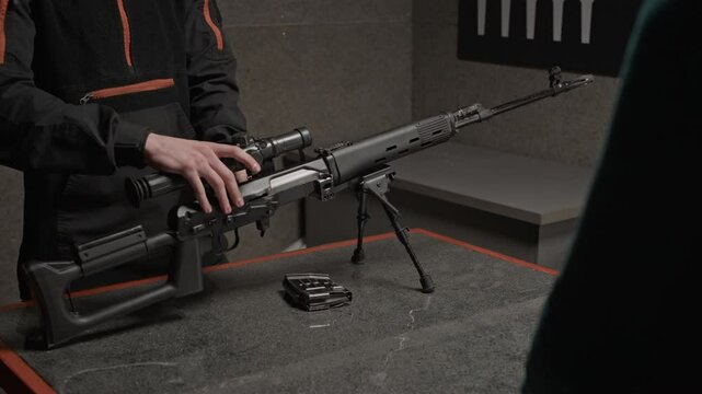 Cropped shot of professional explaining structure of rifle to trainees in shooting club