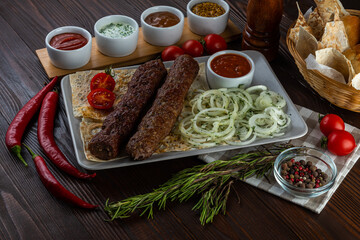 Beef kebab with sauces on wooden background