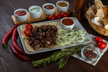 Shashlik with sauces and fresh bread on wooden background