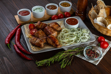 Shashlik with sauces and fresh bread on wooden background