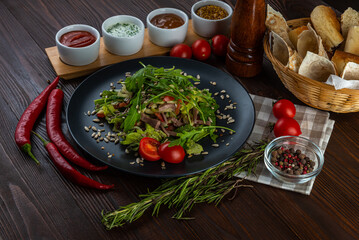 Roast beef salad with grilled vegetables on wooden background
