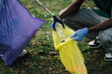 Volunteers picking up plastic bottle trash in park cleanup event